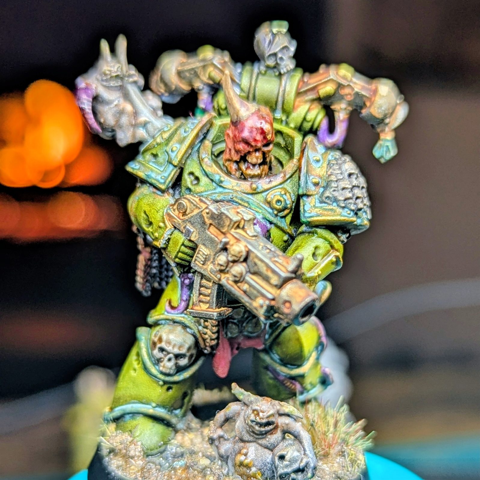 Hand-painted Death Guard miniature in weathered green armor carrying a heavy firearm.